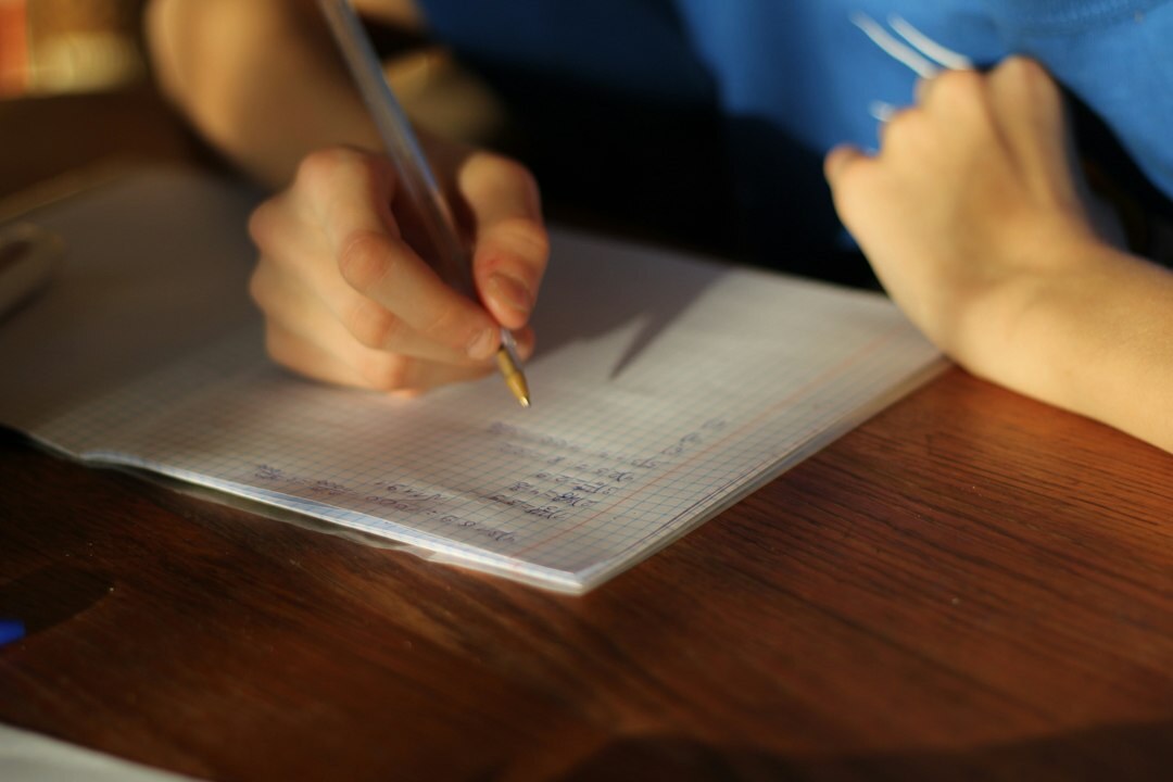 Close up of hands writing a checklist on paper with a pen